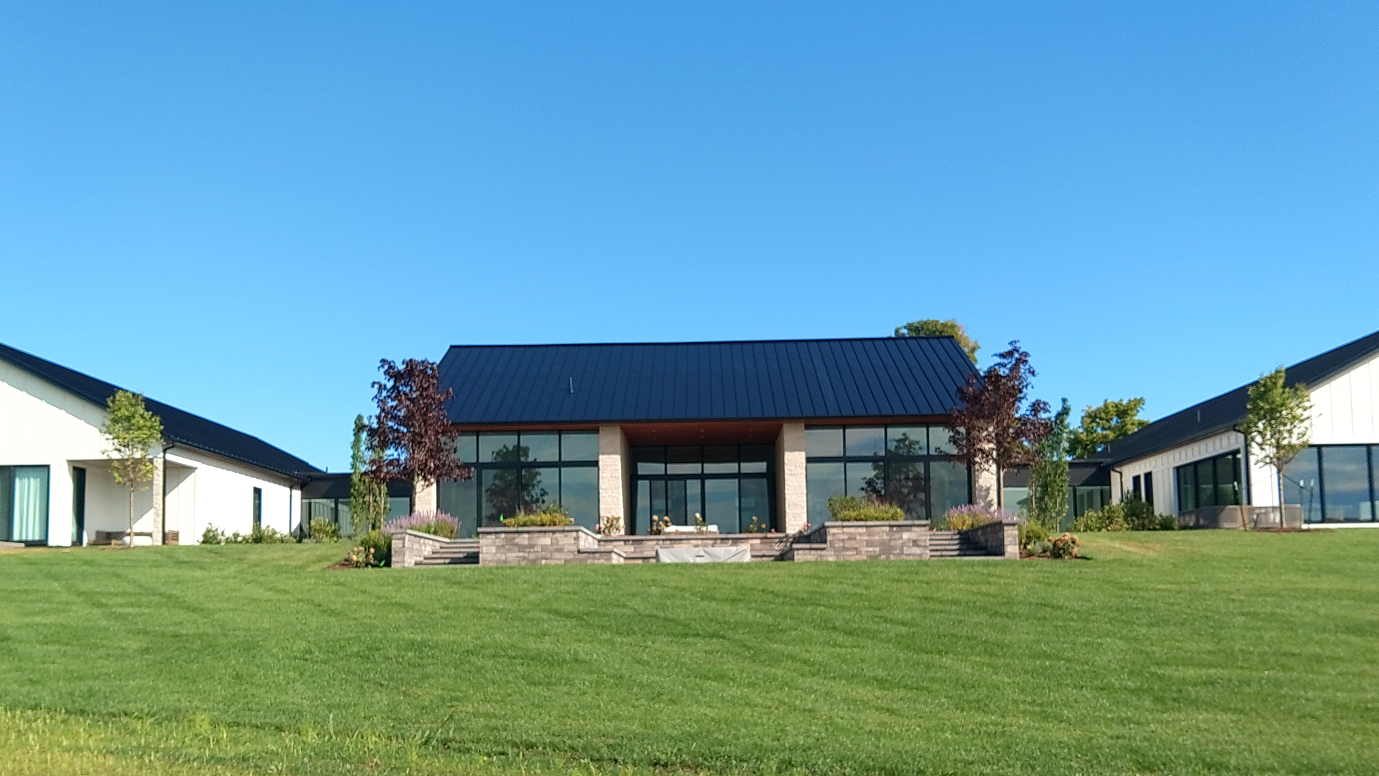 Black standing seam metal roof over a glass great room in Suttons Bay MI