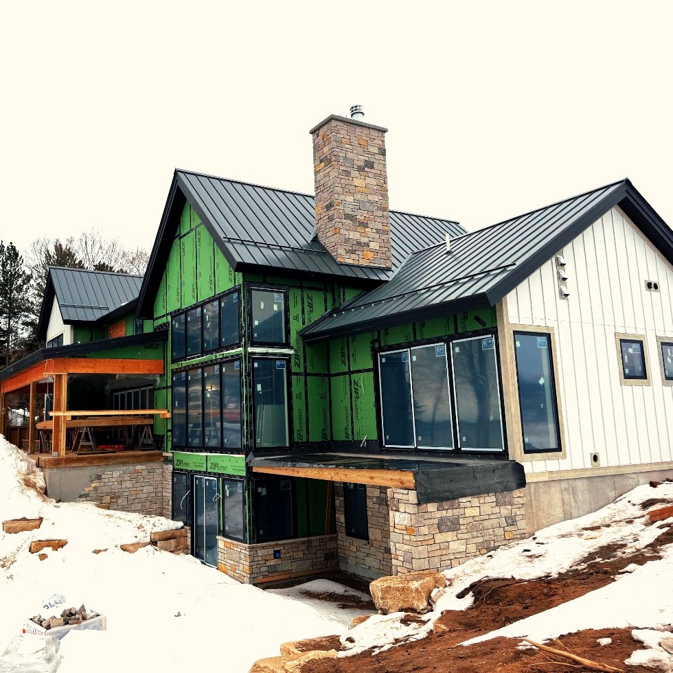 Black standing seam metal roof on a modern farmhouse in Old Mission MI