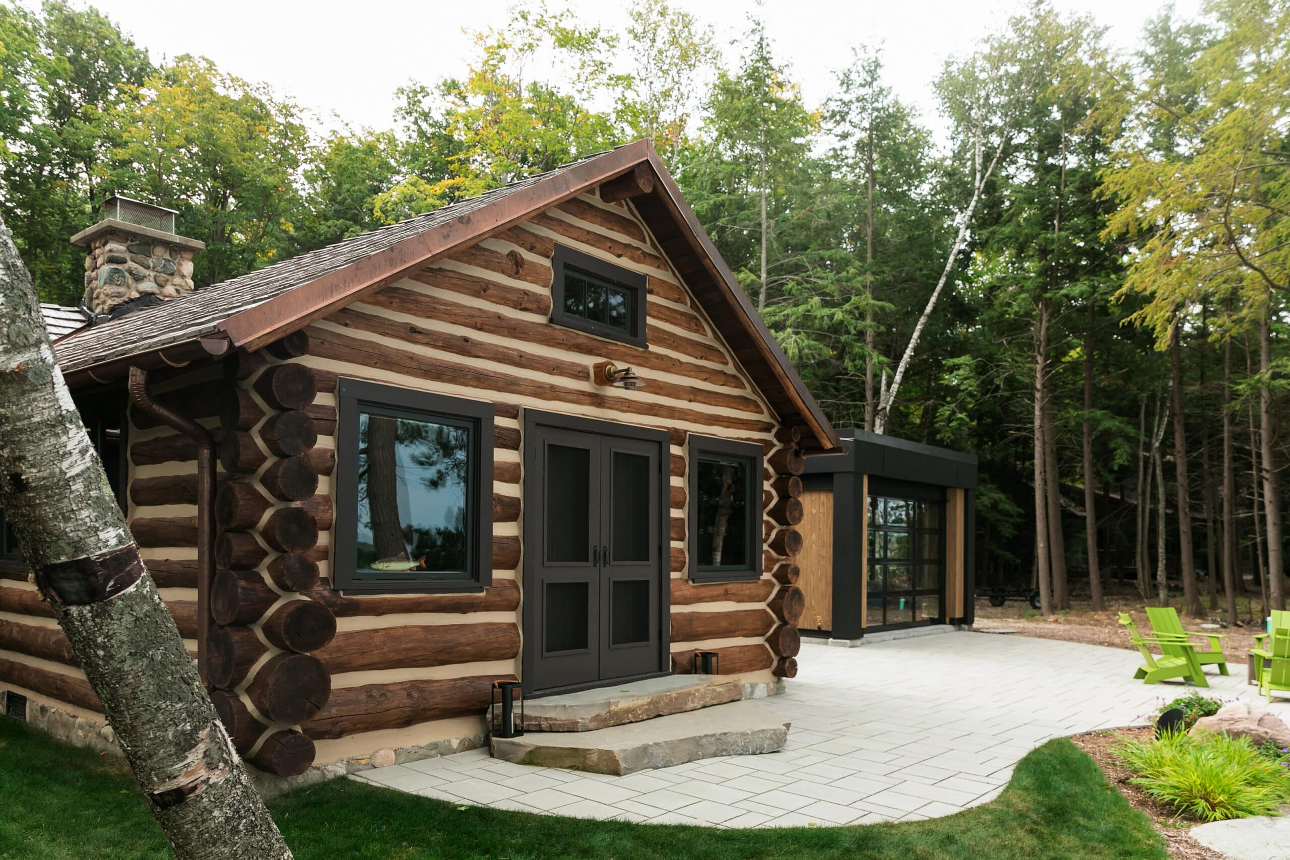 Black standing seam metal roof on a log home in Torch Lake MI