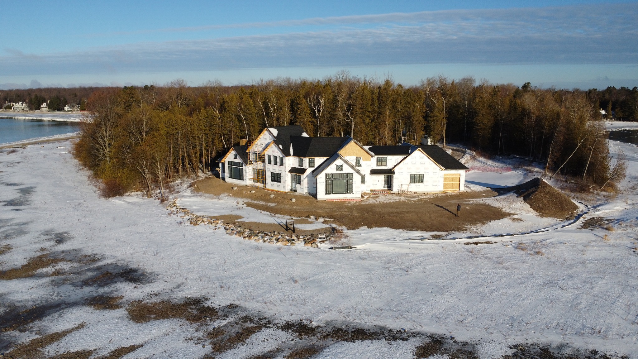 Standing seam metal roofing on a lakefront new build in Northport MI, winter aerial