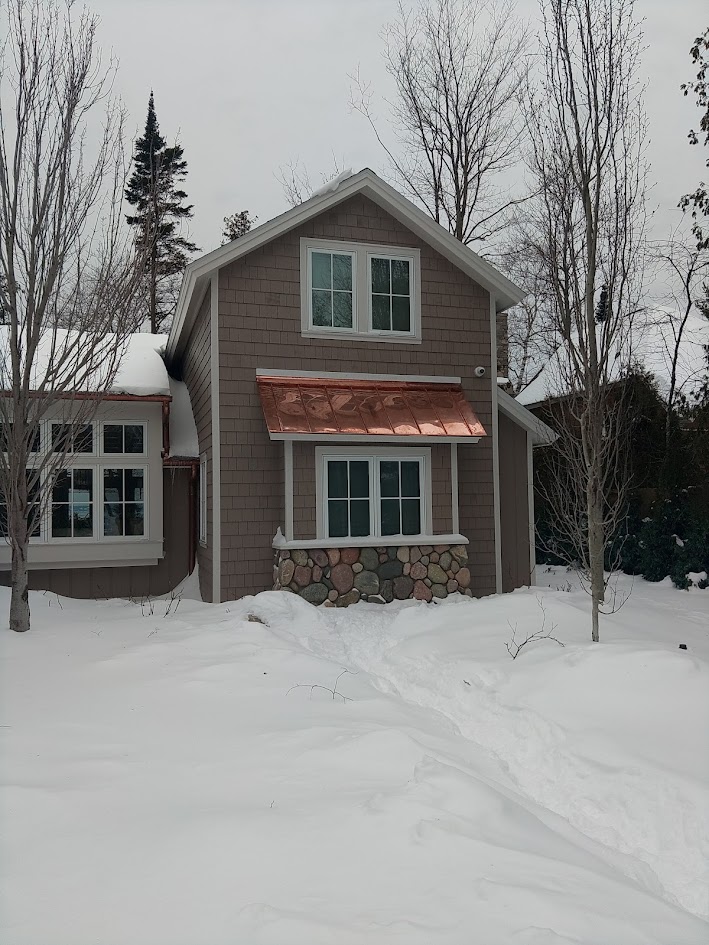 Copper standing seam accent roof over a bay window in Eastport MI