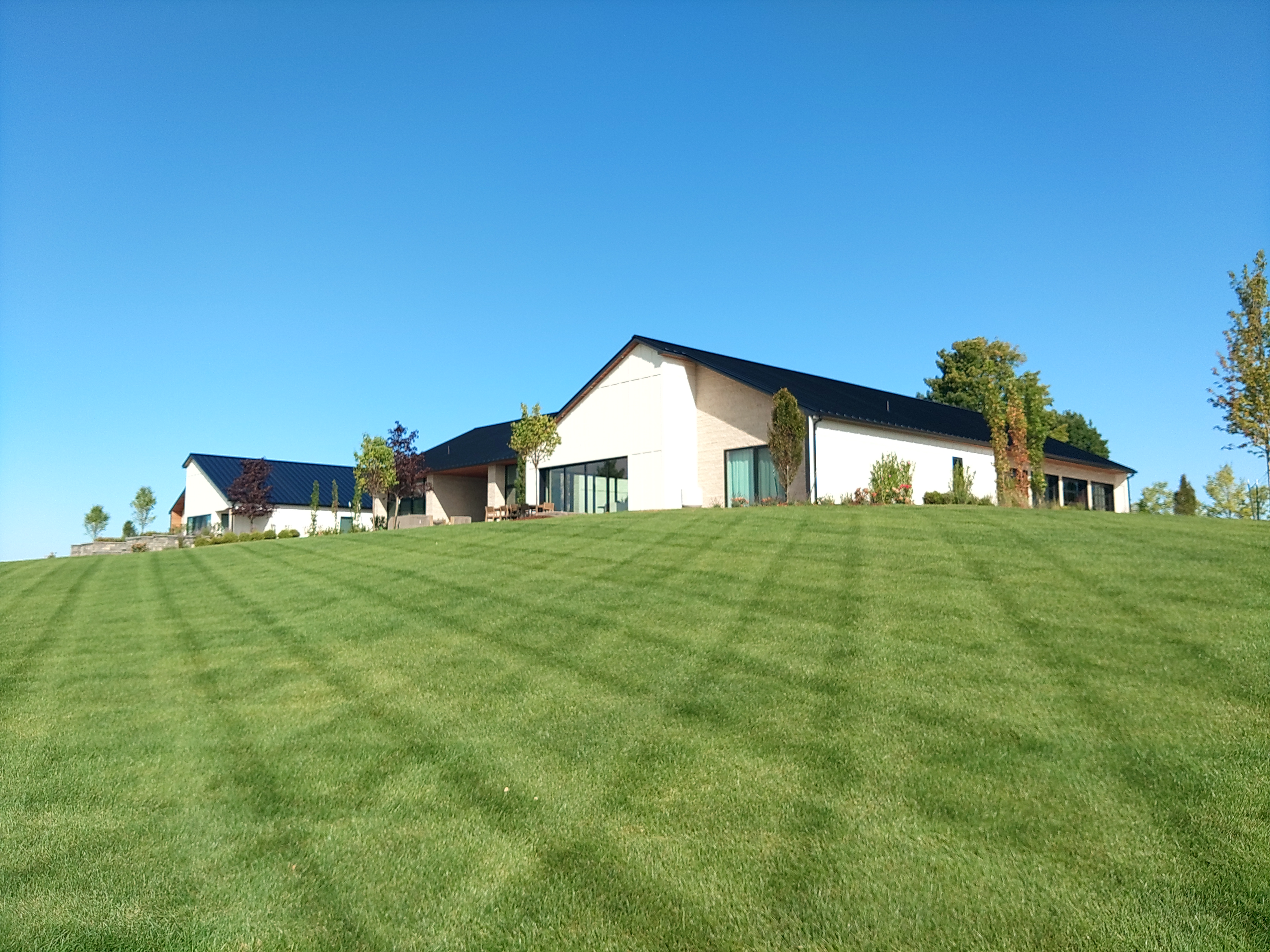 Black standing seam metal roof on a modern ranch on a green hill in Suttons Bay MI