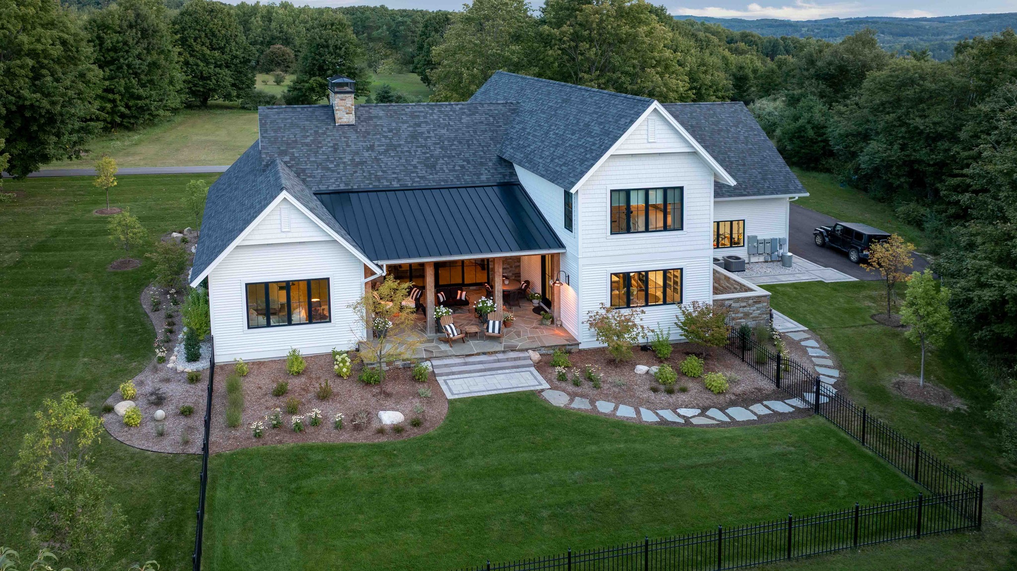 Aerial of a white farmhouse with a black standing seam porch roof in Lake Leelanau MI