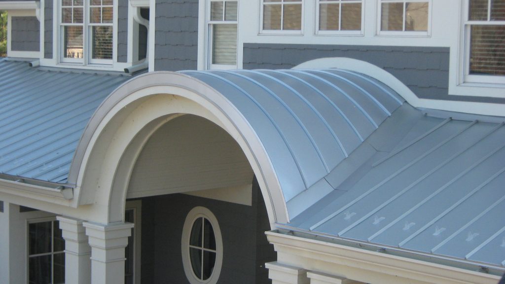 Custom radius standing seam metal roof curved over an entryway
